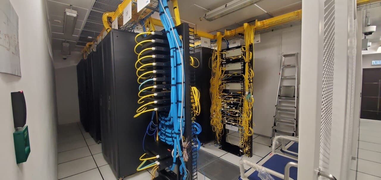 Advanced networking infrastructure with blue and yellow cable organization systems for high-availability hosting