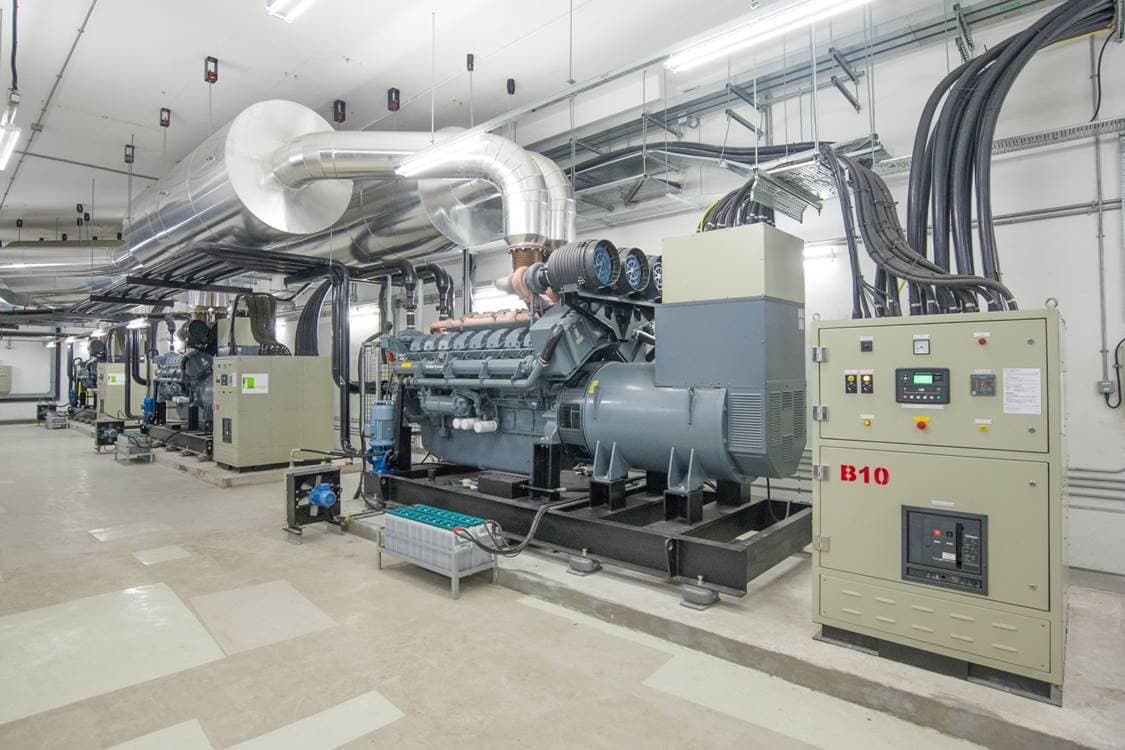 Industrial backup power generators with exhaust systems and control panels ensuring continuous operation for mission-critical data center infrastructure