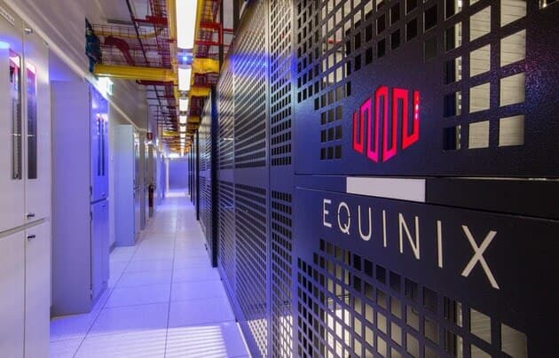 Equinix data center corridor with illuminated server cabinets featuring red logo branding and perforated doors for optimal airflow