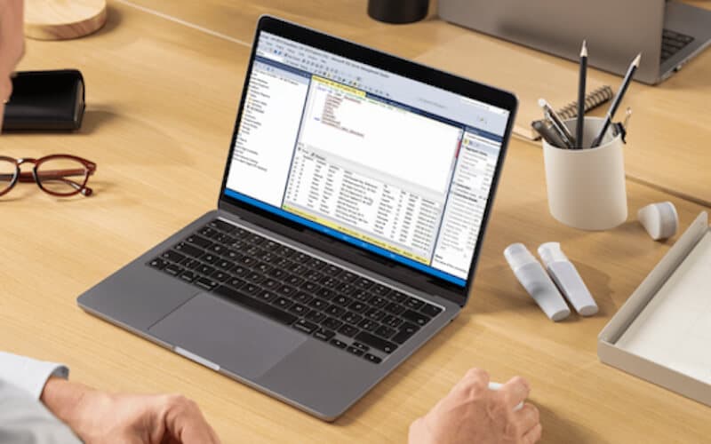 A workspace setup with a laptop displaying a business dashboard, highlighting enterprise application hosting and database management. A workspace setup with a laptop displaying a business dashboard, highlighting enterprise application hosting and database management.