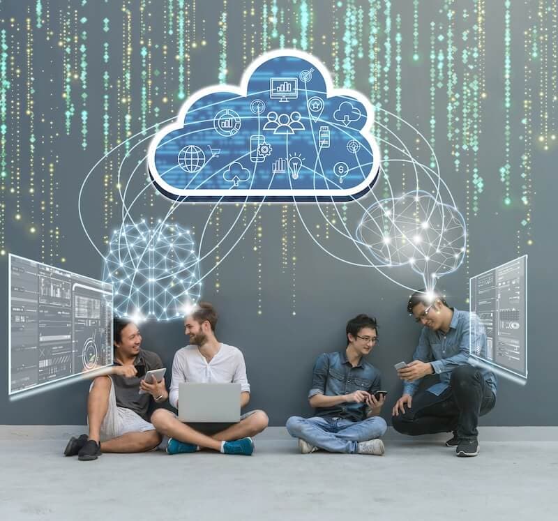 Four people sit casually, engaging with digital devices, beneath a digital cloud icon connected to virtual screens. Four people sit casually, engaging with digital devices, beneath a digital cloud icon connected to virtual screens.