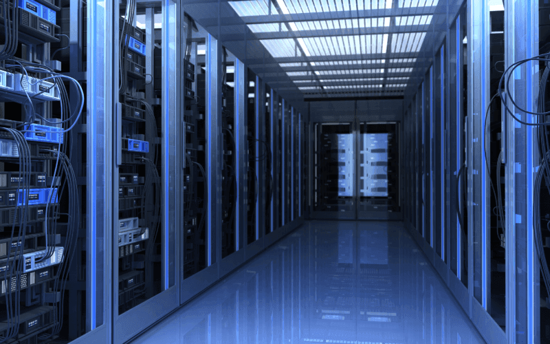 A sleek, futuristic server room with rows of blue-lit server racks on both sides. Cables and equipment fill the space, conveying high-tech efficiency. A sleek, futuristic server room with rows of blue-lit server racks on both sides. Cables and equipment fill the space, conveying high-tech efficiency.