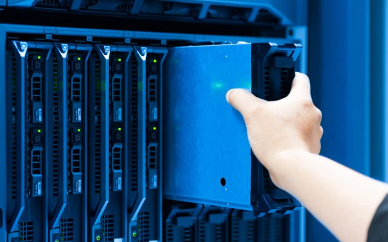 IT engineer repairing a server in a datacenter. IT engineer repairing a server in a datacenter.
