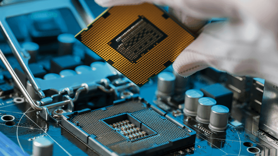 A gloved hand carefully places a gold-toned CPU into a motherboard socket. The focus is on the intricate connections, evoking precision and technology. A gloved hand carefully places a gold-toned CPU into a motherboard socket. The focus is on the intricate connections, evoking precision and technology.