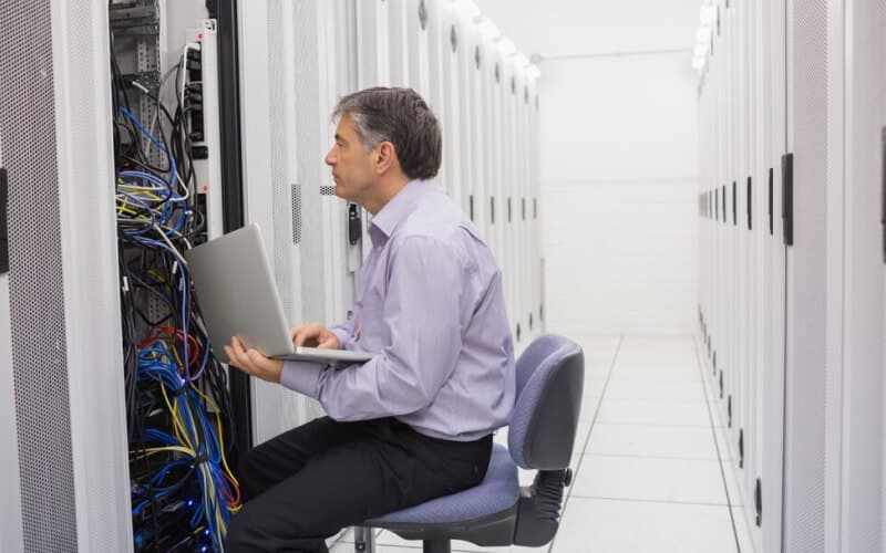 Technician controlling the server with a laptop. Technician controlling the server with a laptop.
